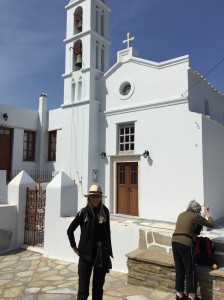 A lady in black and white infront of a blue and white church - art!